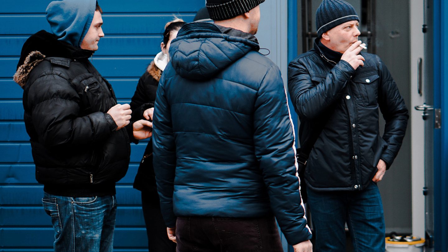 Men in a group, smoking